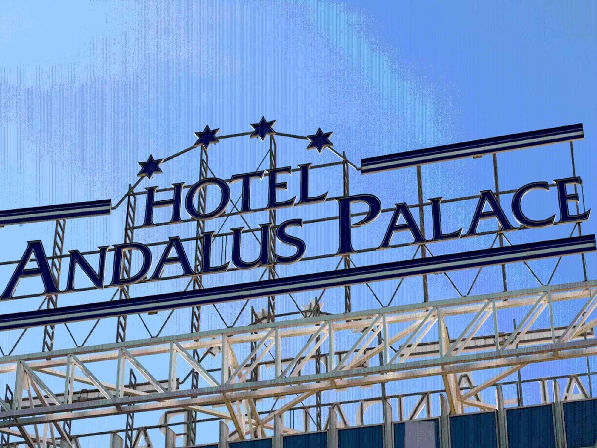 Silken Al-Andalus Palace Seville Exterior photo The photo shows the sign for "Hotel Andalus Palace." The sign is prominently displayed with a blue background and white lettering. Above the name, there are three decorative stars. The overall look is modern and inviting, set against a clear blue sky